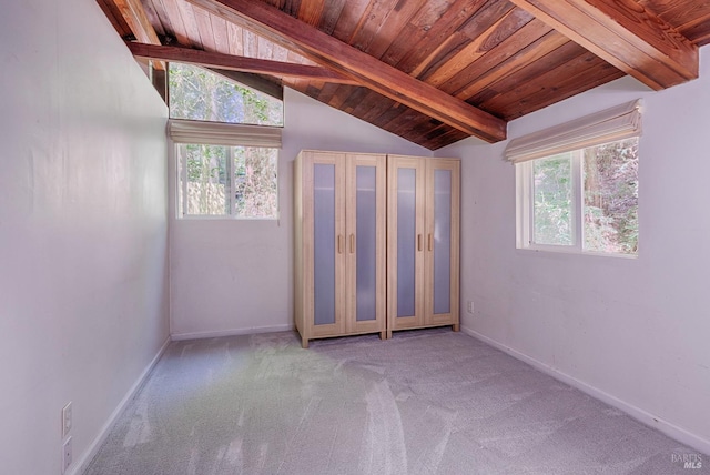 carpeted empty room with baseboards, wooden ceiling, and lofted ceiling with beams