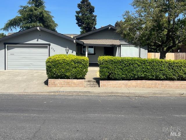230 Lawrence St, Fairfield, CA 94533 - view of front of house with a garage, concrete driveway, fence, and stucco siding