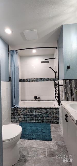 230 Lawrence St, Fairfield, CA 94533 - bathroom with tile walls, vanity, toilet, tiled shower / bath, and a wainscoted wall