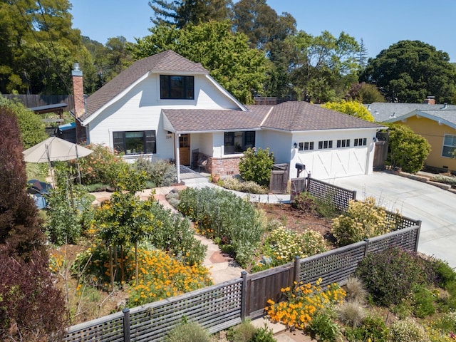 view of front of property with driveway, fence, a garage, and roof with shingles