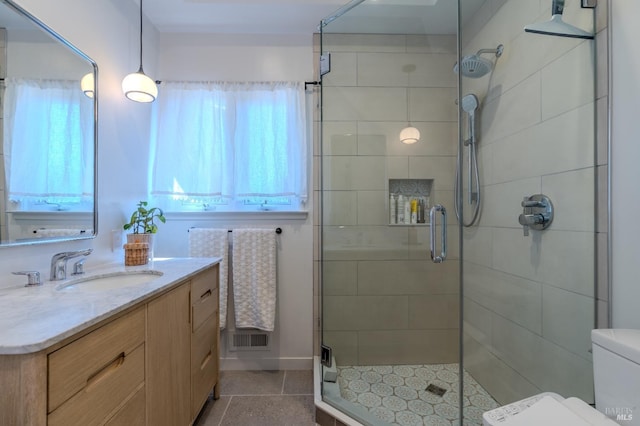 full bath with toilet, a stall shower, a healthy amount of sunlight, and vanity