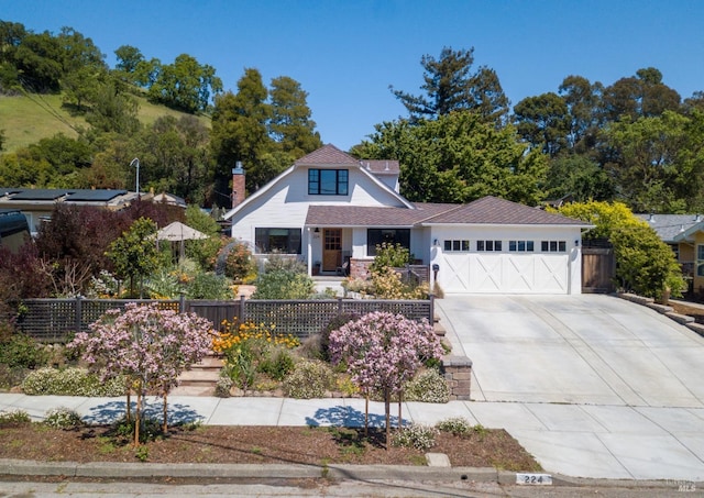 view of front of home with driveway, fence, and a garage