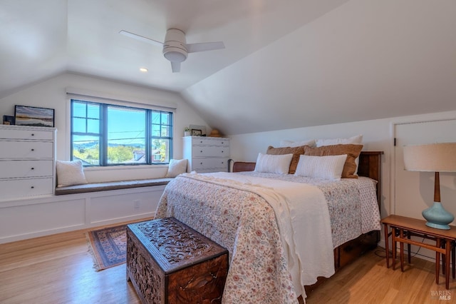 bedroom with light wood-type flooring, vaulted ceiling, and a ceiling fan