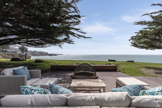wooden deck featuring a water view and an outdoor living space with a fire pit
