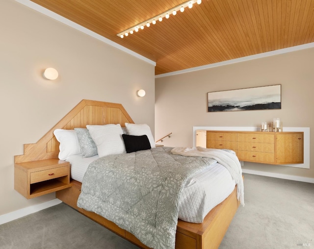carpeted bedroom with rail lighting, wooden ceiling, baseboards, and ornamental molding