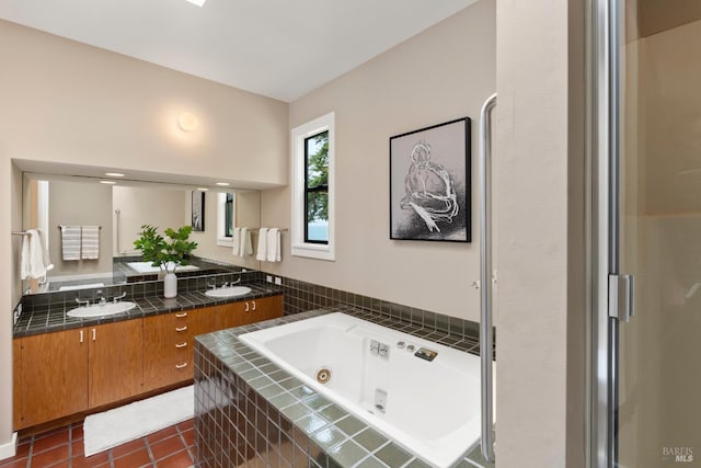 bathroom with tile patterned floors, double vanity, a sink, and a tub with jets