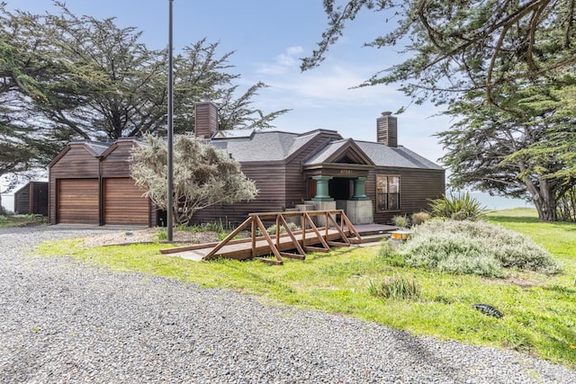 view of front of property featuring a chimney and driveway