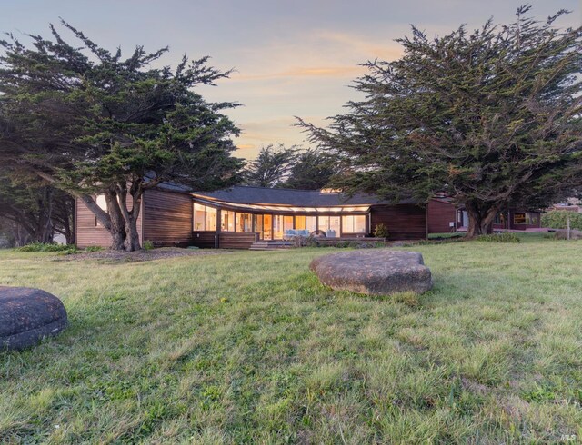 back of property with a lawn