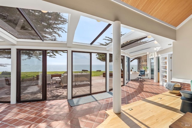 unfurnished sunroom featuring tile patterned floors and a water view