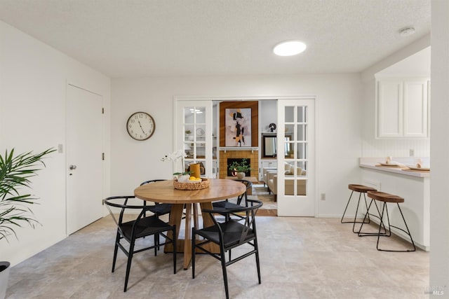 1009 Tilton Rd, Sebastopol, CA 95472 - dining area featuring french doors, a textured ceiling, and a fireplace