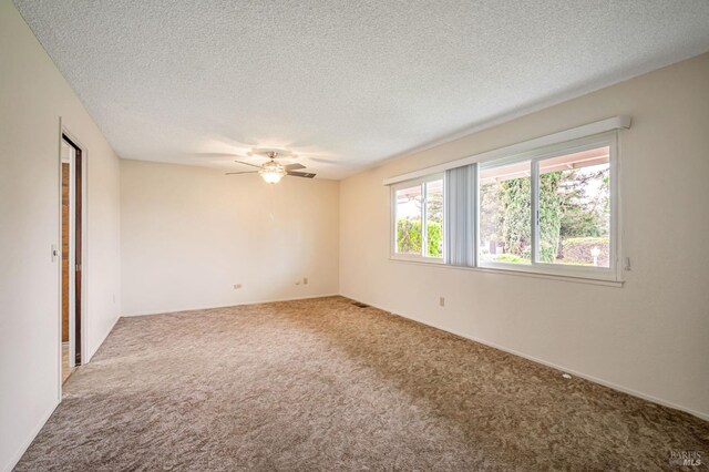 empty room featuring carpet flooring, a ceiling fan, a textured ceiling, and baseboards