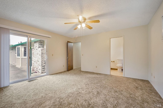 unfurnished bedroom with a textured ceiling, visible vents, access to exterior, and carpet