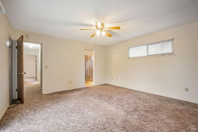 carpeted empty room with a textured ceiling and ceiling fan