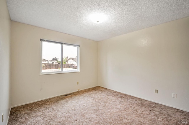 unfurnished room featuring a textured ceiling, visible vents, baseboards, and carpet