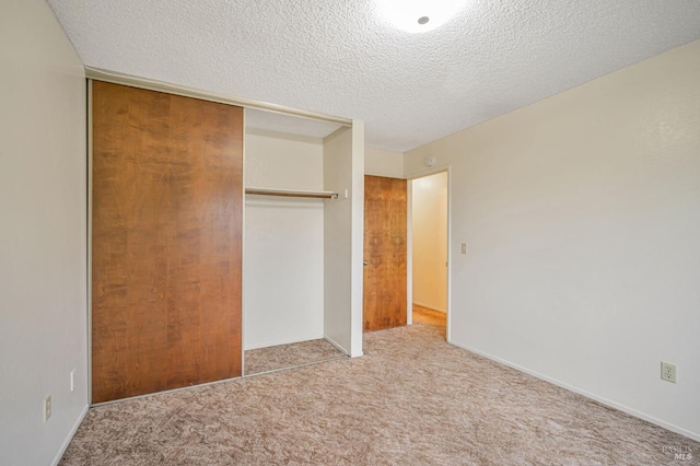 unfurnished bedroom featuring a closet, a textured ceiling, and carpet