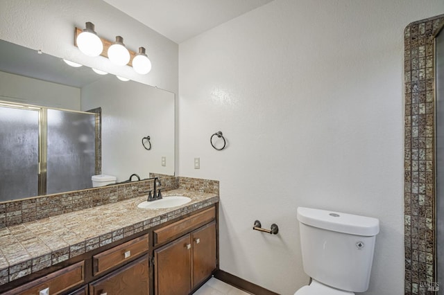 bathroom featuring vanity, baseboards, toilet, and a shower stall