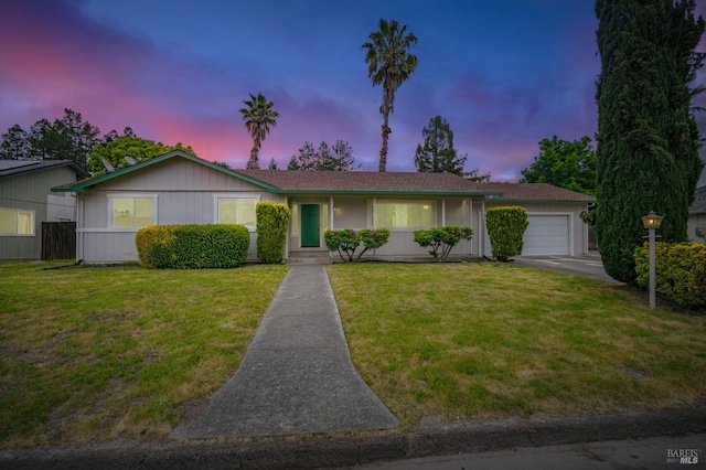 ranch-style house featuring an attached garage and a yard