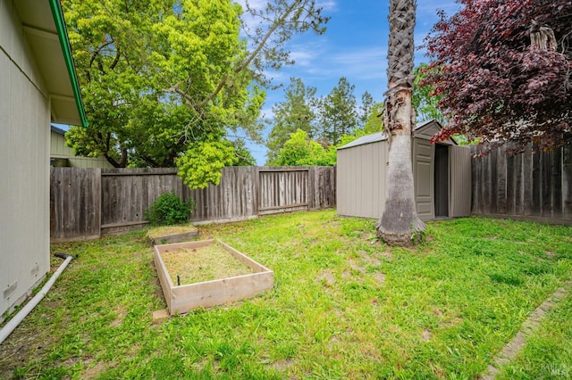 view of yard featuring a storage shed, an outbuilding, a fenced backyard, and a vegetable garden