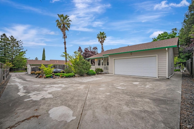 single story home with an attached garage, fence, and concrete driveway