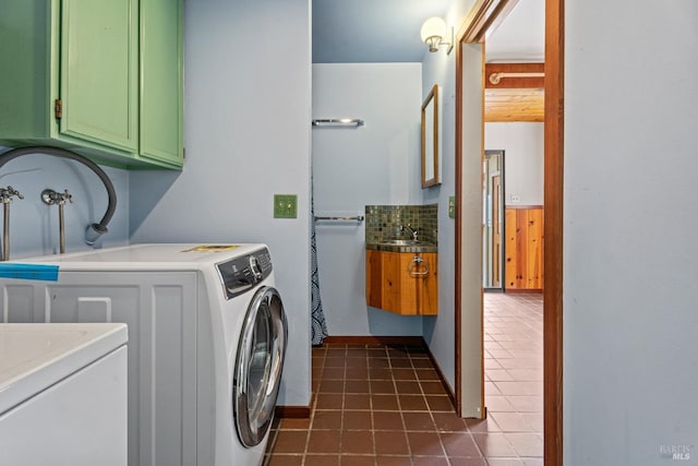 clothes washing area featuring washer hookup, dark tile patterned flooring, and a sink
