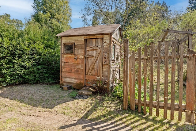 view of shed featuring fence