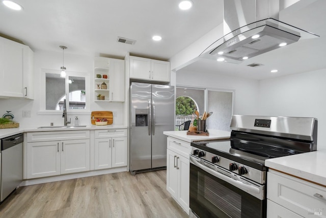 kitchen with white cabinets, a sink, visible vents, wall chimney range hood, and appliances with stainless steel finishes