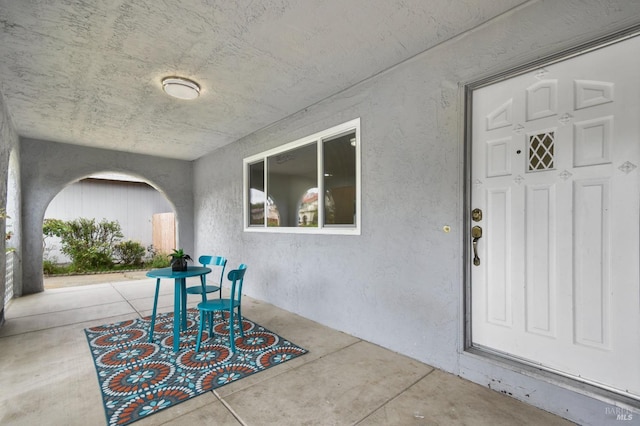view of exterior entry with a patio area and stucco siding