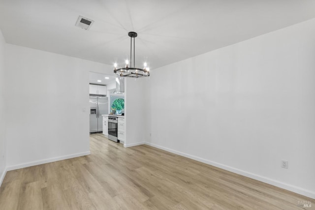 unfurnished dining area featuring baseboards, a notable chandelier, visible vents, and light wood-type flooring