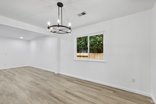 spare room with recessed lighting, an inviting chandelier, visible vents, light wood-style floors, and baseboards