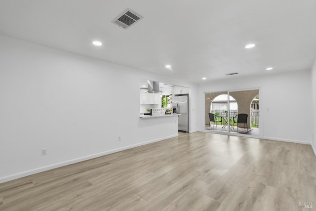 unfurnished living room with recessed lighting, visible vents, light wood finished floors, and baseboards