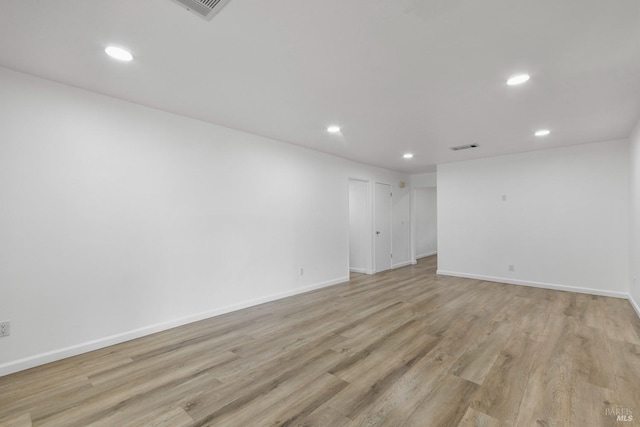 empty room with recessed lighting, light wood-type flooring, and baseboards