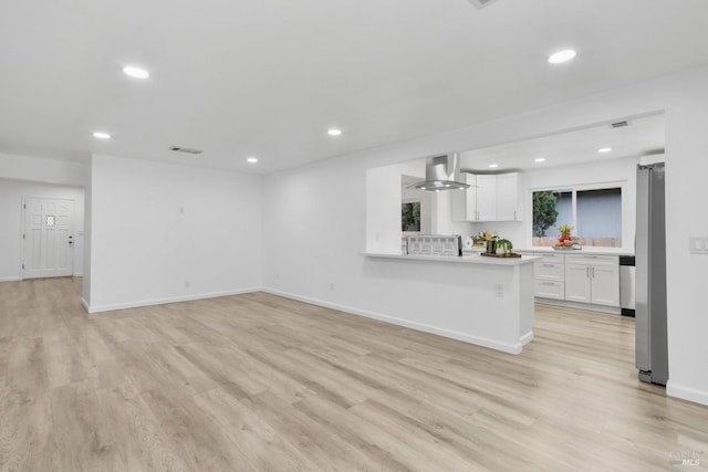 unfurnished living room featuring baseboards, light wood-style floors, and recessed lighting