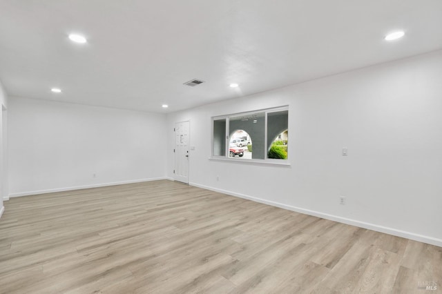 spare room featuring baseboards, light wood-style floors, visible vents, and recessed lighting