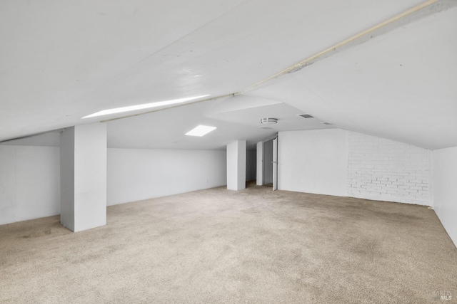 additional living space with carpet floors, visible vents, and lofted ceiling