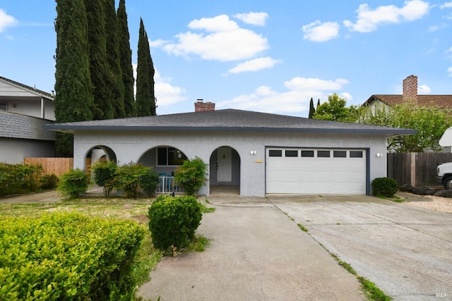 ranch-style home featuring a chimney, driveway, fence, a garage, and stucco siding