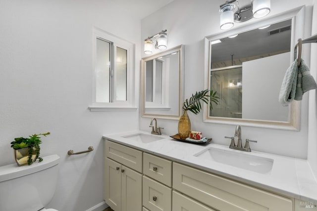 full bathroom featuring visible vents, a sink, a shower with shower door, and toilet