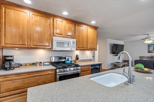 7350 Rasmussen Way, Rohnert Park, CA 94928 - kitchen with stainless steel range with gas cooktop, a ceiling fan, a sink, white microwave, and light stone countertops