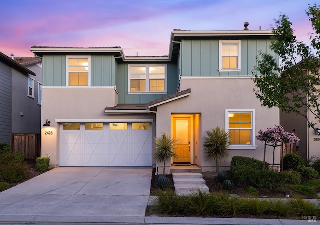 view of front of property featuring a garage, driveway, board and batten siding, and a tiled roof