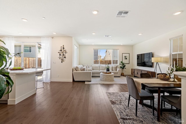 dining room with plenty of natural light, visible vents, baseboards, and dark wood-style floors