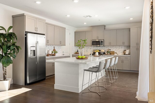 kitchen featuring decorative backsplash, appliances with stainless steel finishes, and gray cabinetry