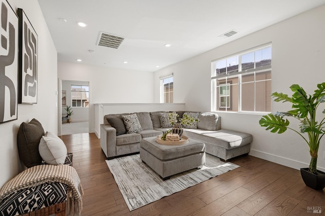 living area featuring hardwood / wood-style flooring, baseboards, and visible vents