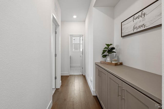 hallway with baseboards, dark wood-style floors, and recessed lighting