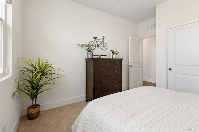 carpeted bedroom featuring baseboards and visible vents