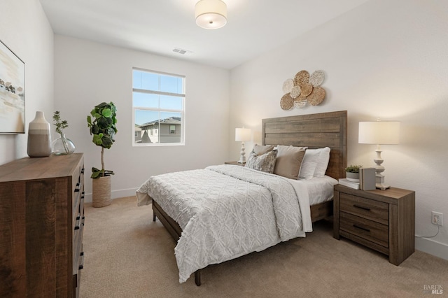 bedroom featuring baseboards, visible vents, and light colored carpet