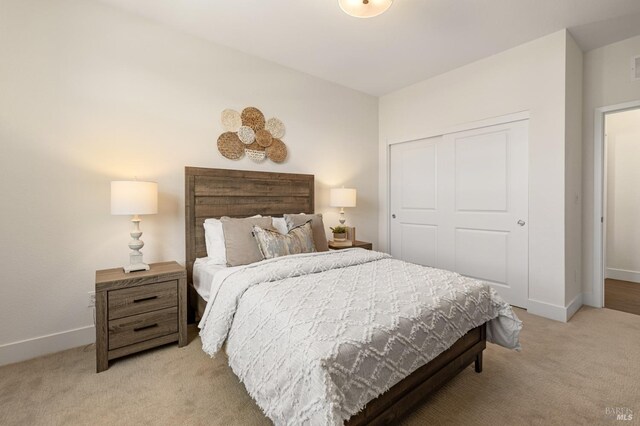 bedroom with visible vents, light carpet, baseboards, and a closet