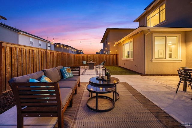 patio terrace at dusk with a fenced backyard and outdoor lounge area