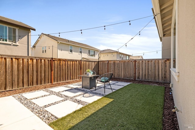 view of yard featuring a residential view, a fenced backyard, and a patio