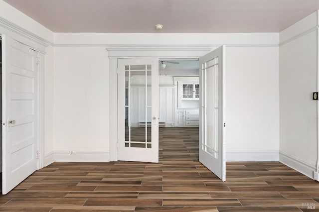 unfurnished room with ceiling fan, a baseboard radiator, and dark wood-style floors