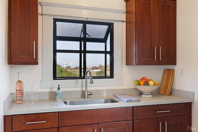 kitchen with light stone counters and a sink