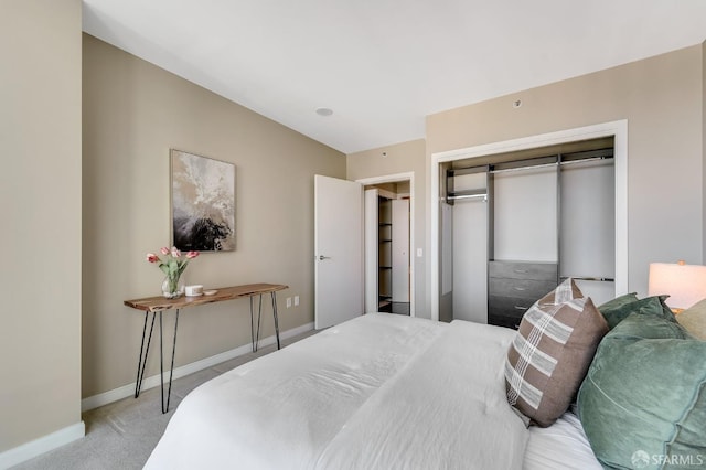 carpeted bedroom featuring a closet and baseboards